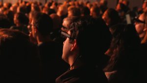 Een theaterbezoeker draagt smart glasses waarmee realtime vertaling met AR wordt geprojecteerd vlak naast de spelers. De bril is speciaal bedoeld voor dove, slechthorende en niet-Nederlandstalige bezoekers. Een project van Het Nationale Theater.